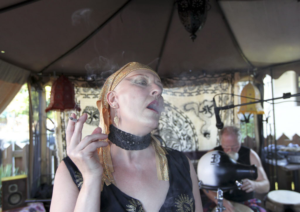 (Pamela Luminaire smokes a joint Saturday at Mint Tea on Main Street, where patrons can smoke marijuana in designated areas, in Vancouver. -Natalie Behring)