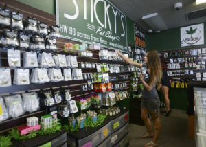 Alex Merrell, a manager at Sticky's Pot Shop in Vancouver, organizes merchandise Aug. 1. The store has been closed. (Columbian files)