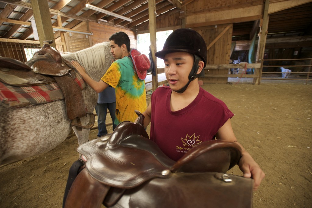 (J.J. Macaraeg, 17, from Seattle, right, and Luis Herrera, 17, from Vancouver, tend to horses at Daybreak Youth Services Horse Ranch in Battle Ground, Friday, September 5, 2014. -Steven Lane/The Columbian)