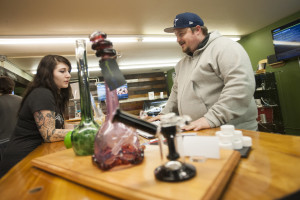 New Vansterdam retail marijuana shop assistant Jacy Reichlin helps customer Matt Ellis on Monday in Vancouver. The Vancouver City Council on Monday voted to increase the number of retail pot shops in the city from six to nine. (Photos by Natalie Behring/The Columbian)